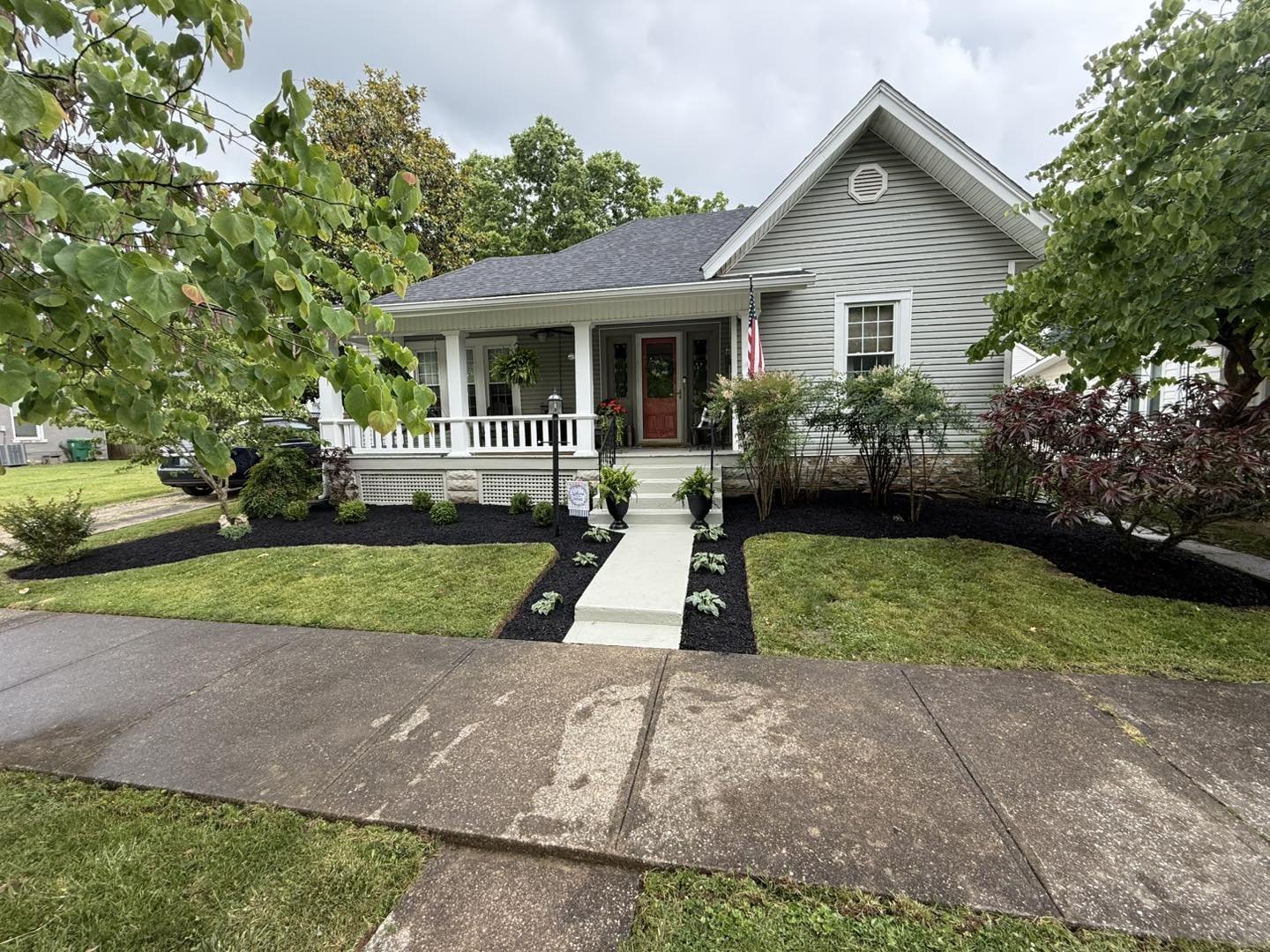 A beautifully landscaped home with mulched walkway and freshly cut striped lawn, maintained by Marquez Lawn Maintenance
